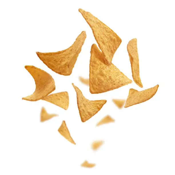 Corn chips of triangular shape levitate on a white background.