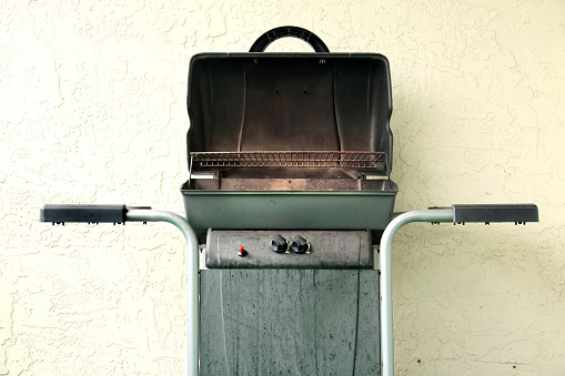 Barbecue grill by building exterior wall