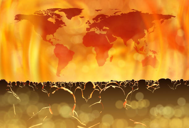 Climate change concept of burning world and large group of people conceptual global warming image of fire flames and large group of people. NASA world map image layered and used; https://earthobservatory.nasa.gov/features/NightLights/page3.php apocalypse fire stock pictures, royalty-free photos & images