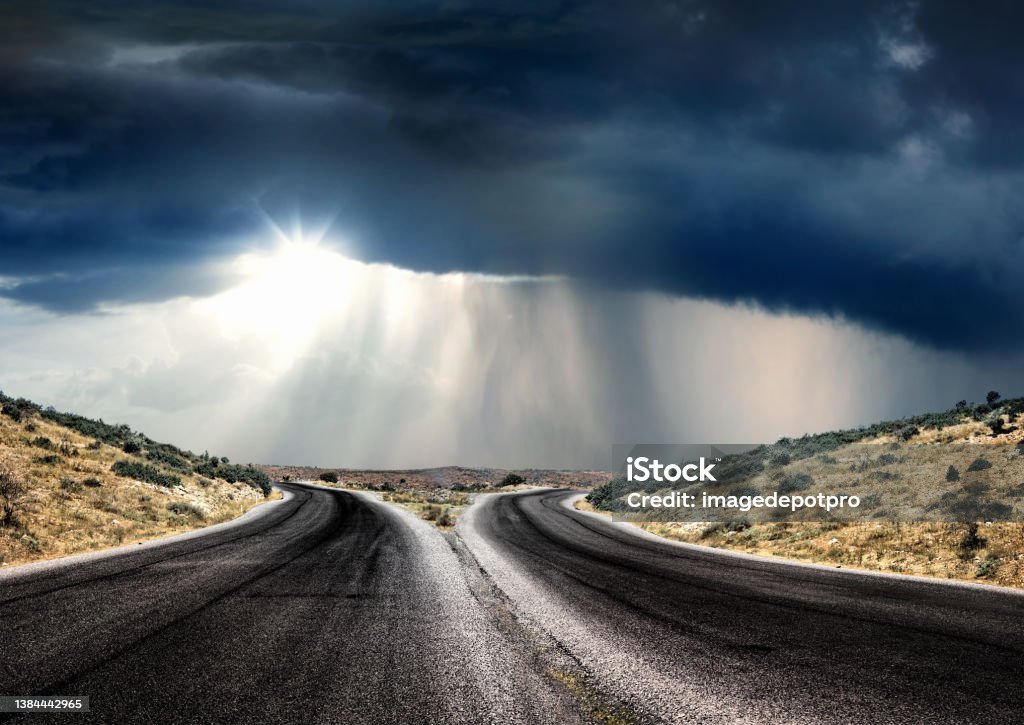 Empty forked road over dramatic stormy sky Forked road over sky Separation Stock Photo