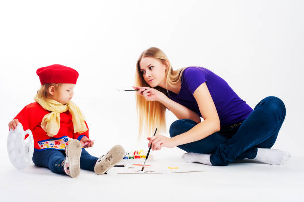 Pretty young mother and daughter drawing stock photo