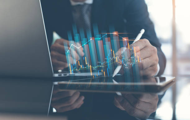 istock Business finance technology concept. Businessman using digital tablet and laptop computer analyzing sales data with economic growth, financial graph 1384443007