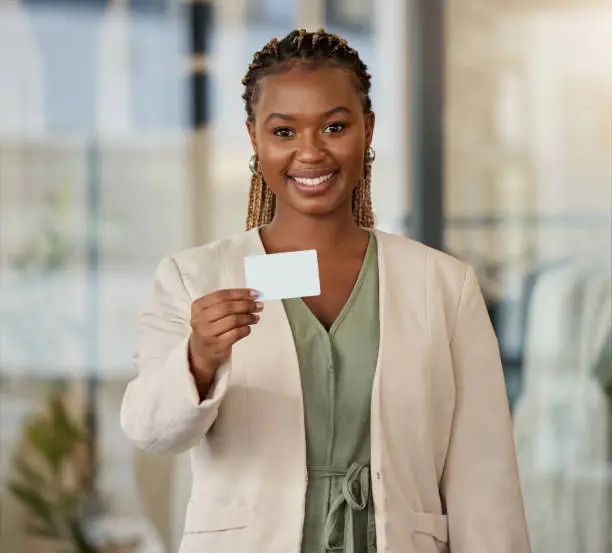 Photo of Portrait of a young businesswoman showing her business card in a modern office