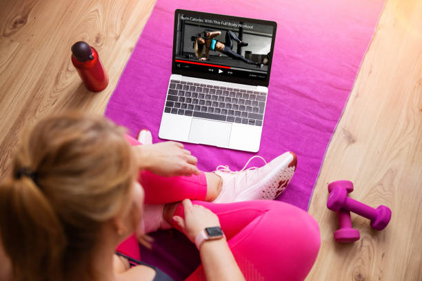 istock Woman watching instructional workout video on laptop 1384447549