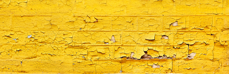 panoramic brick wall with old paint flakes peeling