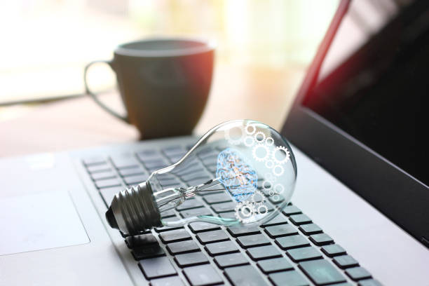 istock light bulb with illustration brain gear  on laptop , idea working concept 1384450281