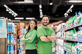 Successful colleagues standing at supermarket and smiling at the camera.man, woman, couple, supermarket, market, buy, purchase, shopping, groceries