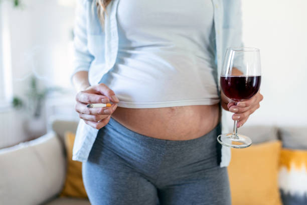 smoking and alcohol pregnancy.woman on a long pregnancy drinking alcohol and smoking cigarettes.problems of alcoholism and the period of bearing a child.danger of losing a baby, miscarriage. alcoholic - eastern european caucasian one person alcoholism imagens e fotografias de stock