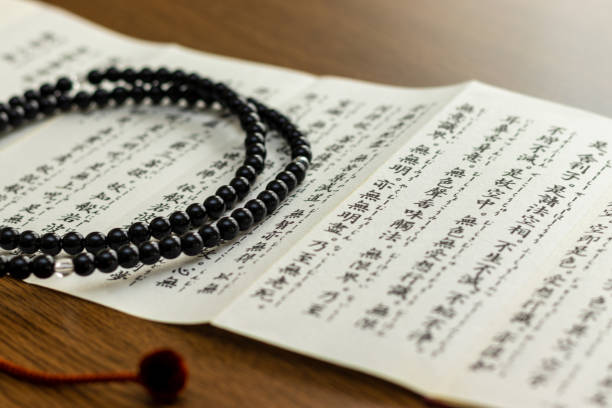 istock Buddhist sutra and rosary on a wooden desk 1384456085
