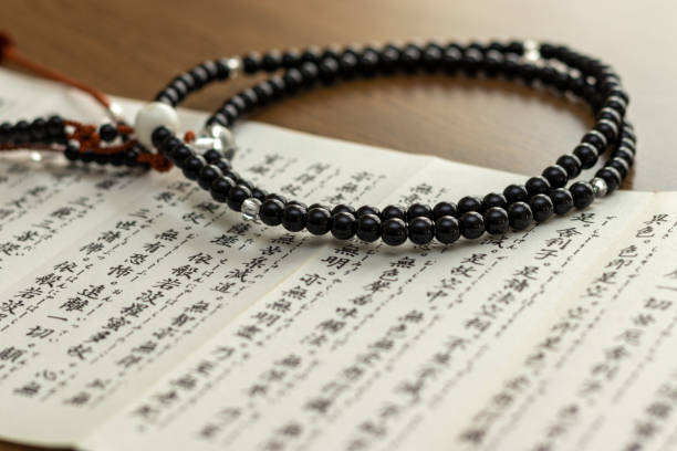 istock Buddhist sutra and rosary on a wooden desk 1384456087