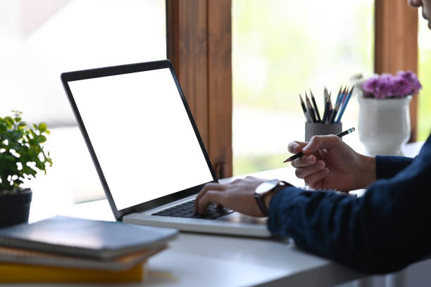 istock Cropped view male office worker holing pen and working with laptop computer. 1384456182