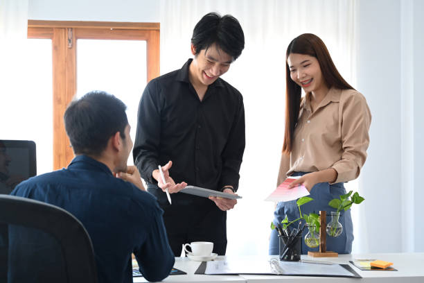 istock Team of graphic designer discussing over new business project in creative office. 1384456196