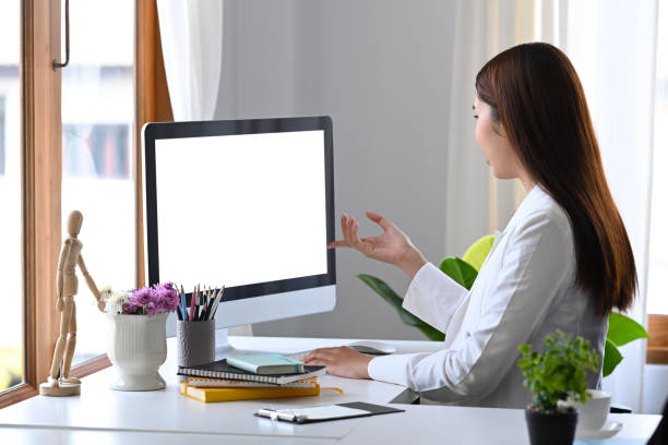 istock Side view asian woman entrepreneur having video conference at modern workplace. 1384456198
