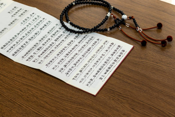 istock Buddhist sutra and rosary on a wooden desk 1384459007