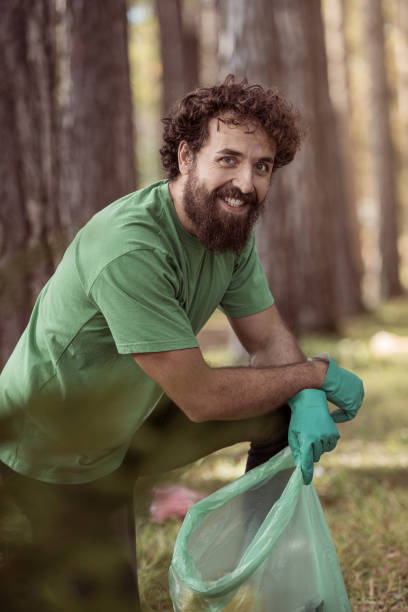 Men collecting garbage in forest stock photo