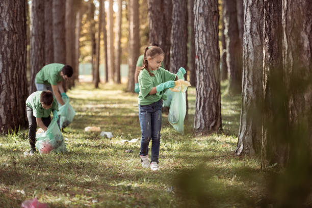 istock Girl putting trash in plastic bag 1384463268