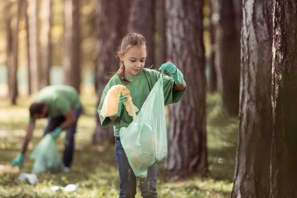 istock Girl putting trash in plastic bag 1384463282