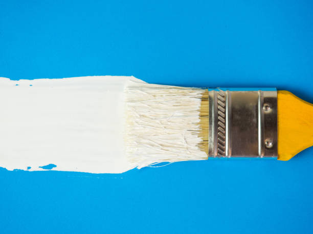istock brush with white paint draws space for text on blue background 1384466880