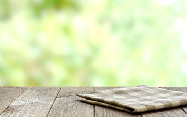 istock An empty brown wooden table. Blurry summer or spring background. 1384468275