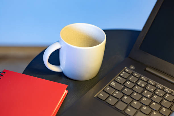 istock White cup, red agenda and laptop on round table. Concept: Working at home taking a break 1384475809