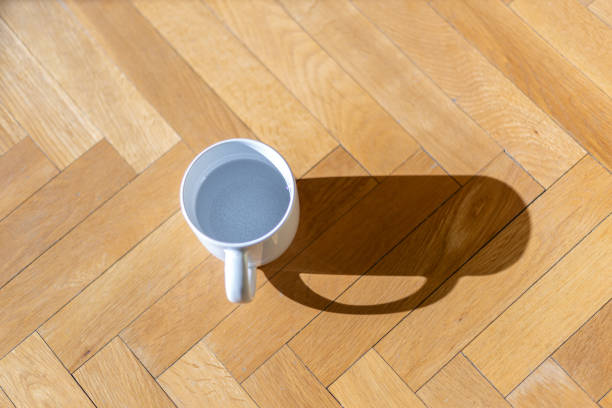 istock Ceramic mug on wood parquet illuminated by natural light. Minimalism 1384476967
