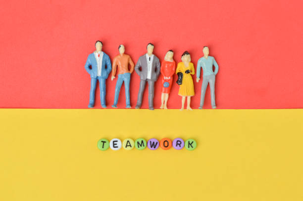 istock People miniatures and colorful alphabet beads with text TEAMWORK. 1384481847