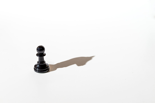 Chess pawn casting the shadow of the horse. Conceptual photography that can illustrate concepts such as leadership, double personality, the inner world of the individual, among others.