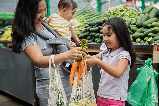 Asian mother with kids shopping in market fresh foods