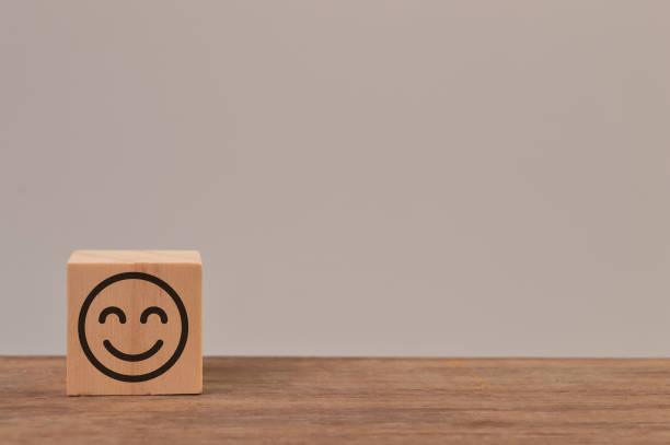 istock Wooden block with smile face icon. Customer evaluation and satisfaction concept 1384488738