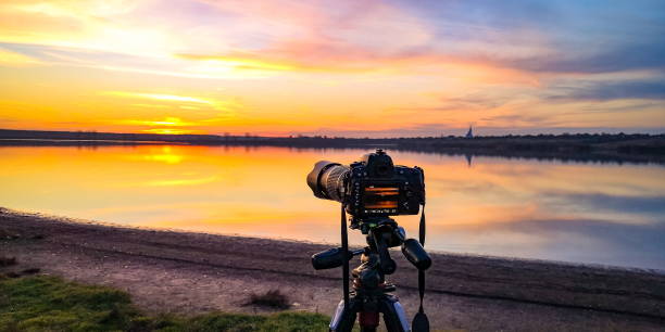 the camera shoots a sunset video on the lake - güneş videolar stok fotoğraflar ve resimler