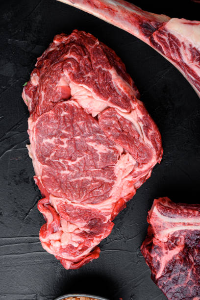 istock Black Angus prime beef rib eye steak, marbled meat, on black stone background, top view flat lay 1384496892