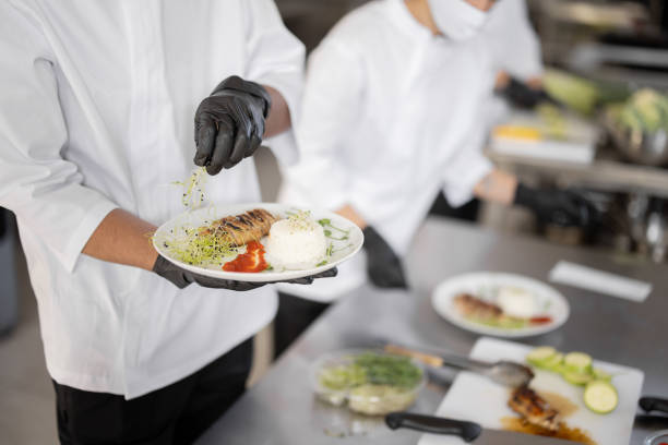 istock Cooks finishing main courses in the restaurant kitchen 1384498110