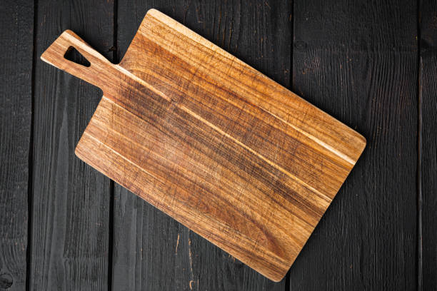 istock Used bamboo chopping board empty for empty for copy space for text or food, top view flat lay , on black wooden table background 1384498648