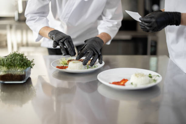 istock Cooks finishing main courses in the restaurant kitchen 1384505494