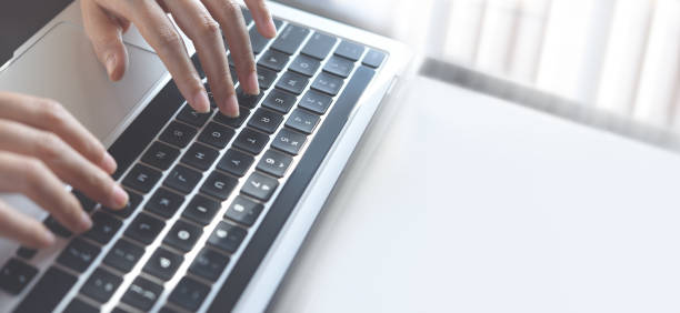 istock Woman hands typing on laptop computer keyboard on glass table, close up 1384514154