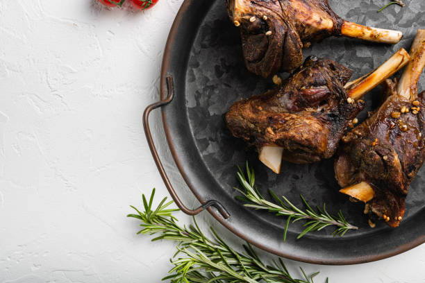 istock Lamb shanks cooked in a rich gravy, on white stone table background, top view flat lay, with copy space for text 1384515752