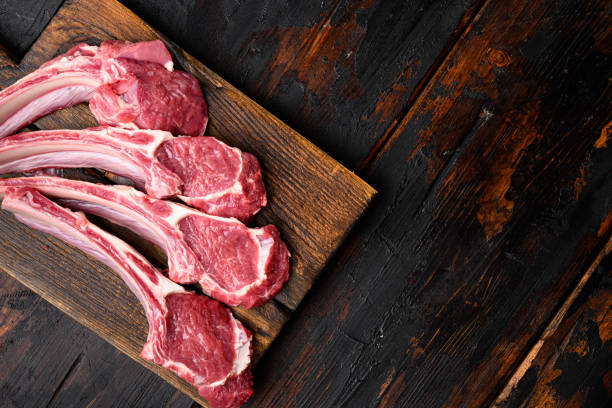 steaks de côtelettes de viande d’agneau, sur un vieux fond de table en bois sombre, vue du dessus à plat, avec espace de copie pour le texte - chop rack of lamb cutlet food photos et images de collection