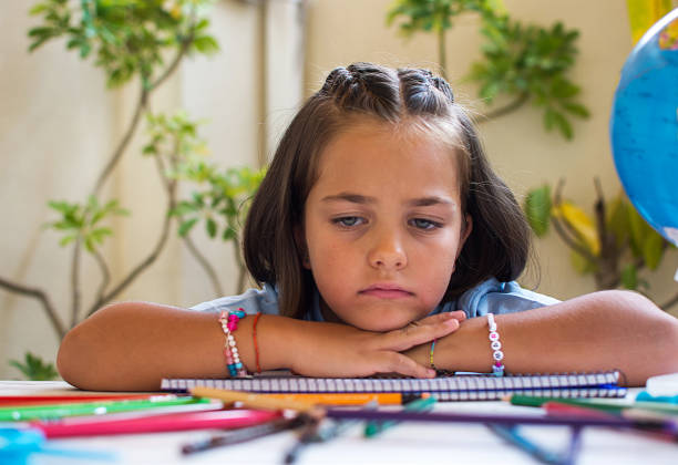 Girl Back To School.Little Girl Doing Homework In The Courtyard Of Her House. 6-year-Old Girl With Blue Eyes Drawing With Colored Pencils.