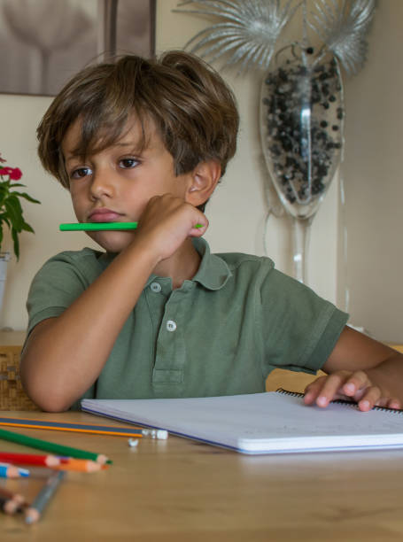 istock Little Boy In The Living Room Doing Homework. 1384516219