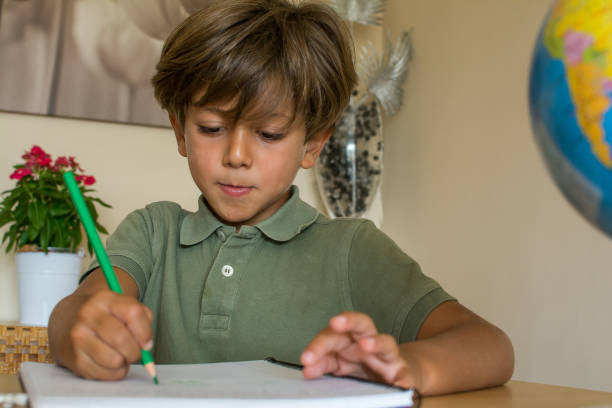 istock Little Boy In The Living Room Doing Homework. 1384516258