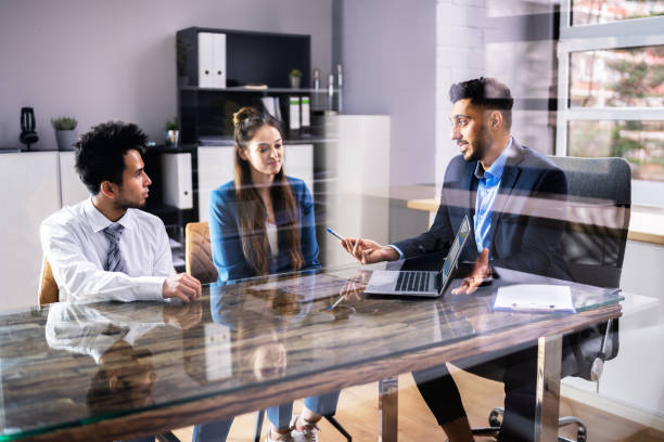istock Young Financial Advisor Showing Graph On Laptop To Couple 1384525879