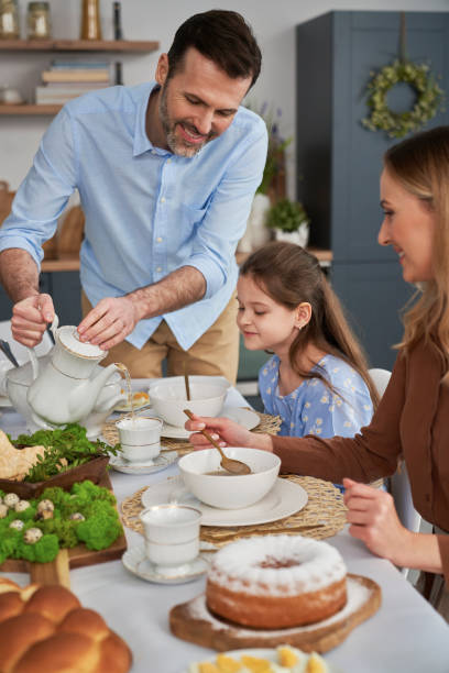 istock Vertical image of father pouring tea during easter dinner 1384526023