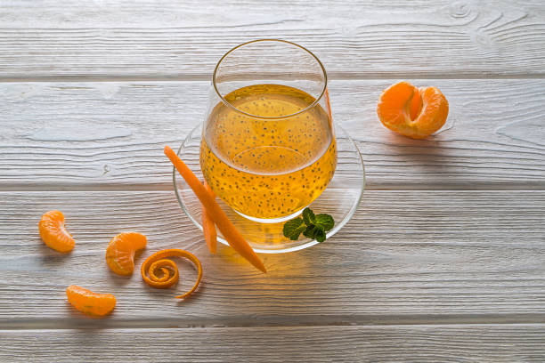 Nutritious tangerine drink with basil seeds and mint. With a carrot on a saucer stock photo