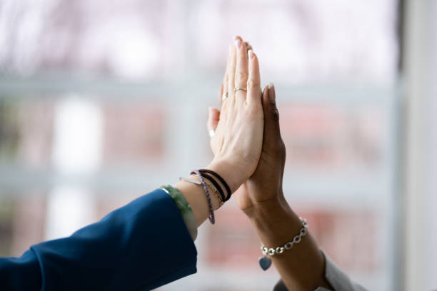 istock Two Smiling Young Businesswomen Giving High Five 1384530130
