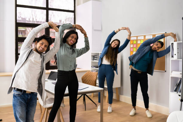 Group Of Happy Young Businesspeople Doing Stretching Exercise