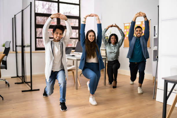 istock Group Of Happy Young Businesspeople Doing Stretching Exercise 1384530154