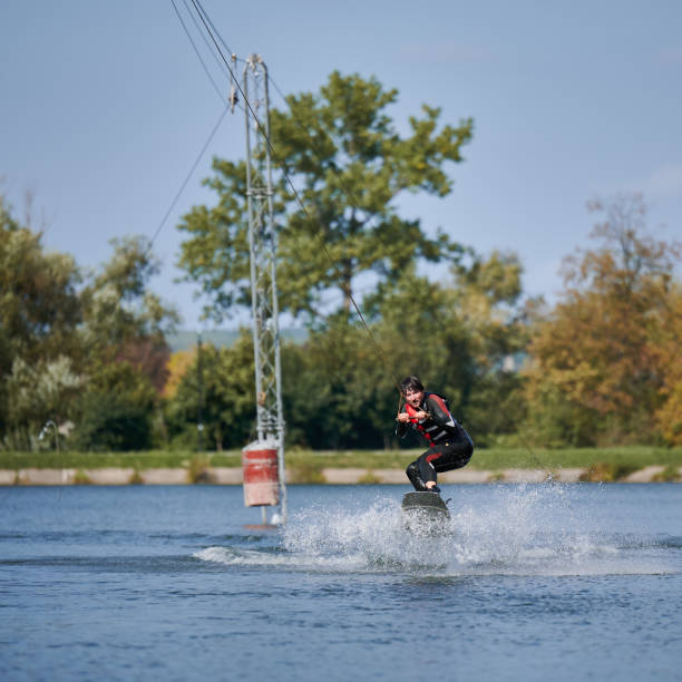 istock Young surfer having fun wakeboarding in the cable park. 1384533806