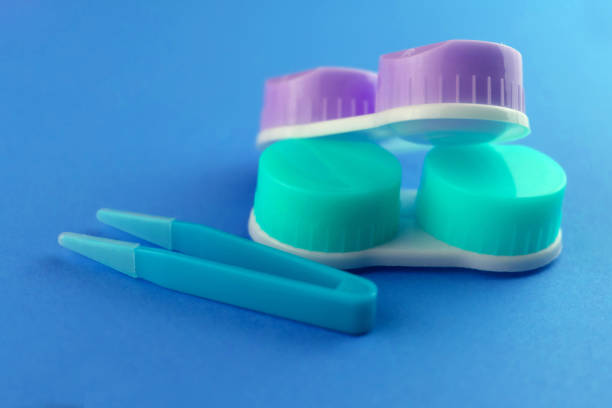 istock Colored cases for contact lenses for eyes on a blue background. 1384536789