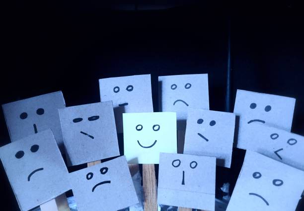 istock Positive attitude concept with hand drawn notes on happy expressions among many bad or sad facial expressions. 1384541773