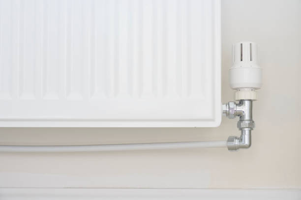 istock New white radiator white on pale wall house interior 1384551894